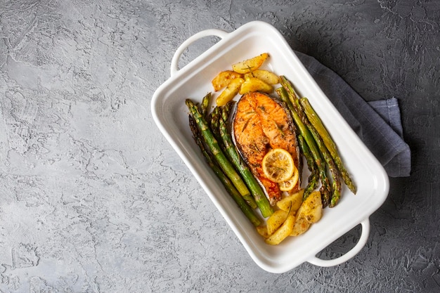 Gegrilde, gebakken zalm geserveerd op een bord met asperges en aardappelen