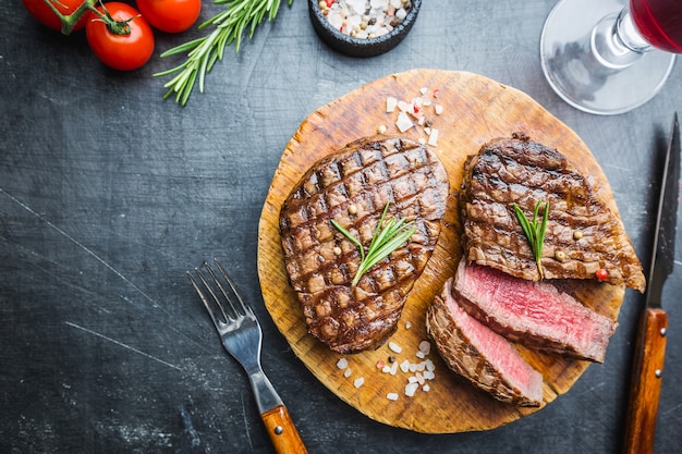 Gegrilde gemarmerde vleesbiefstuk Filet Mignon met kruiden. Sappige biefstuk op snijplank, bovenaanzicht.