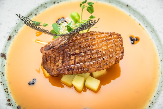 Gegrilde gerookte eend met gele saus eten met groene salade, op een houten achtergrond