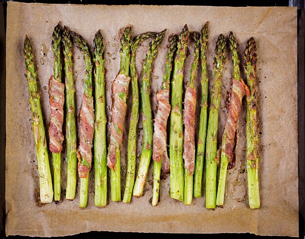 Gegrilde groene asperges omwikkeld met spek. Bovenaanzicht