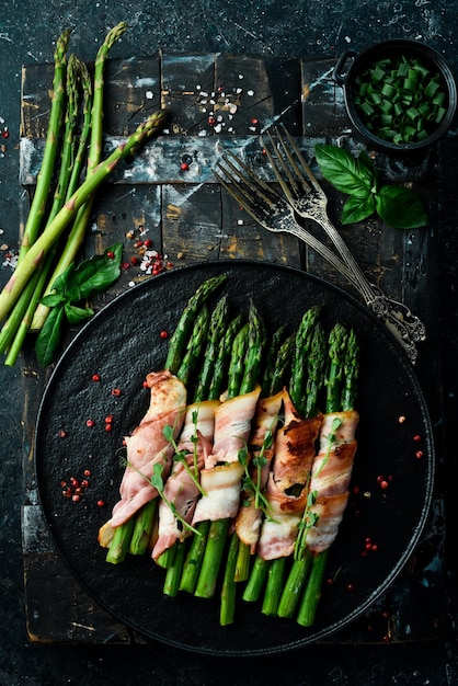 Gegrilde groene asperges omwikkeld met spek Gezonde voeding Op een stenen achtergrond Bovenaanzicht