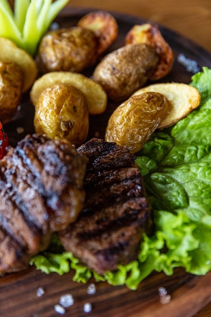 Gegrilde groenten en een stukje heerlijk gegrild vlees op een houten tafel