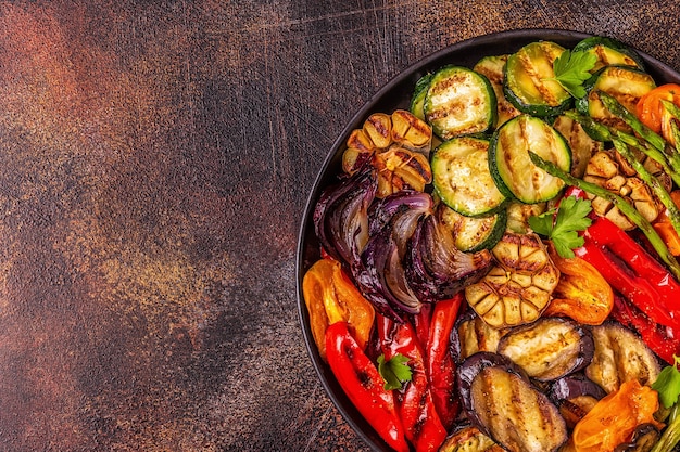 Gegrilde groenten op een bord met saus, bovenaanzicht.