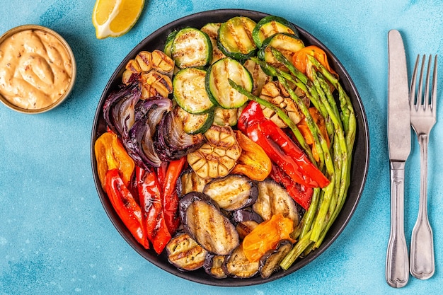Gegrilde groenten op een bord met saus