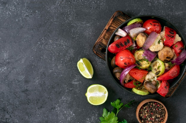 Gegrilde groenten op een zwarte achtergrond. Veganistisch menu. Groentemix in een bord