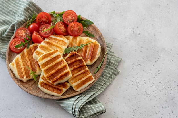 Gegrilde Halloumi-kaas en verse tomatensalade.