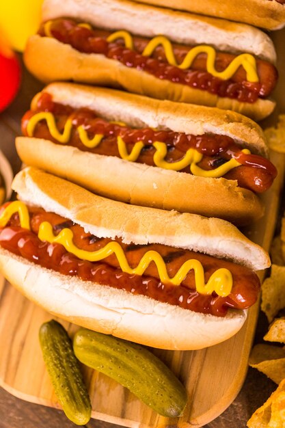 Gegrilde hotdogs op een witte hotdogbroodjes met mosterd en ketchup.