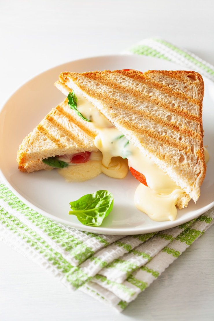Foto gegrilde kaas en tomatensandwich op witte achtergrond