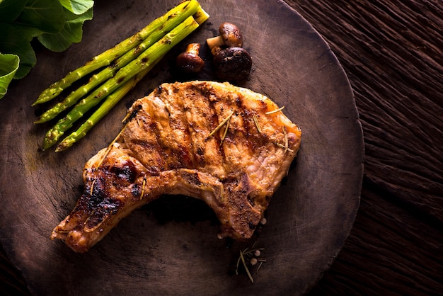 Foto gegrilde karbonade met groente op een houten bord