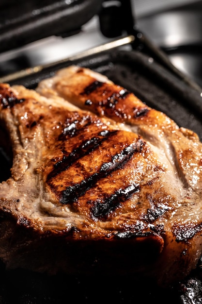 Gegrilde karbonade op grillpan met rozemarijn bovenaanzicht achtergrond