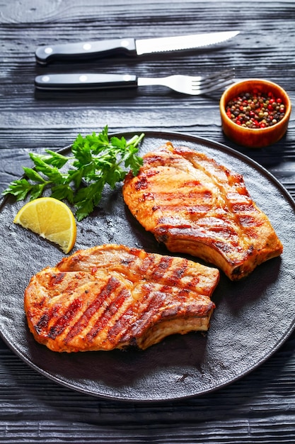 Gegrilde karbonades met been op een zwarte plaat