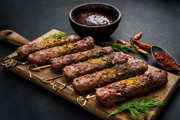 Gegrilde kebab met kruiden en saus op een donkere achtergrond