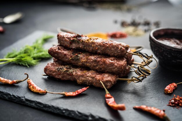 Gegrilde kebab met kruiden en saus op een donkere achtergrond