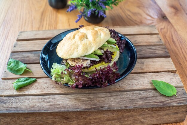 Gegrilde kip en avocado sandwich op houten tafel