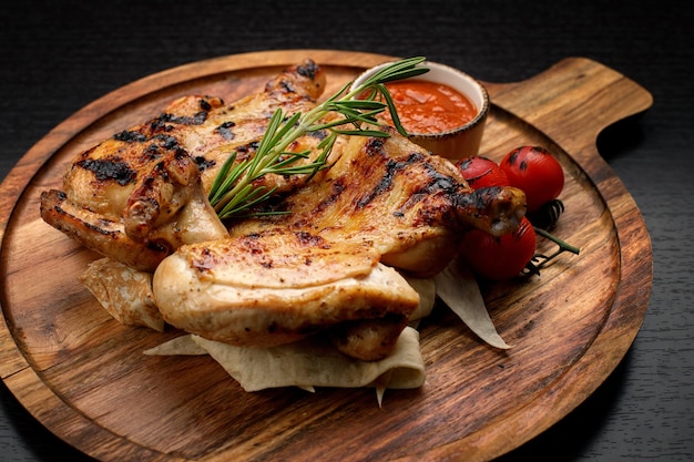 Gegrilde kip met saus op een houten plank