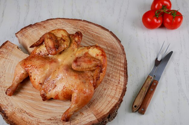 Gegrilde kip Tabaka en tomaten op houten tafel. Georgische keuken