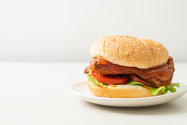 gegrilde kipburger met saus op witte plaat