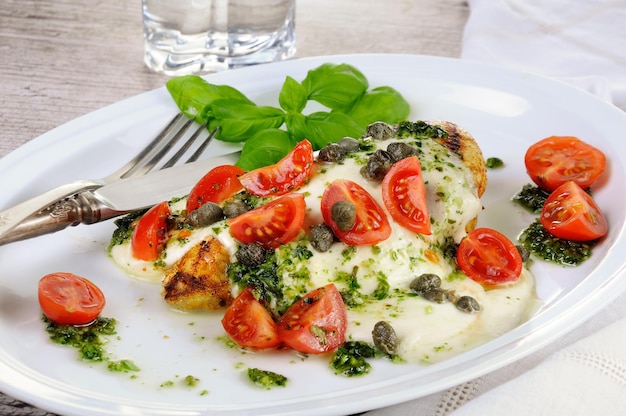 Gegrilde kipfilet gegarneerd met gesmolten mozzarella kaas basilicum pesto tomaat en kappertjes