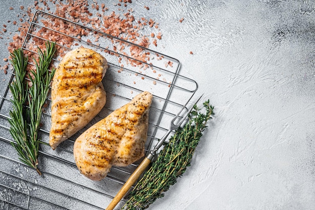 Gegrilde kipfilet steaks gekookt op een zomerse BBQ Grijze achtergrond Bovenaanzicht Kopieer de ruimte