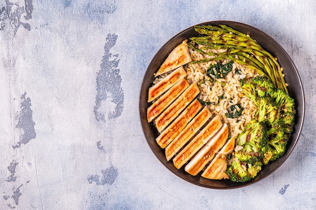 Gegrilde kippenborst met bruine rijst, spinazie, broccoli, asperges, concept van dieet, gezond eten.