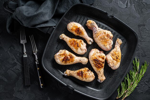 Gegrilde kippenbout drumstick met kruiden, gevogeltevlees. zwarte achtergrond. bovenaanzicht.