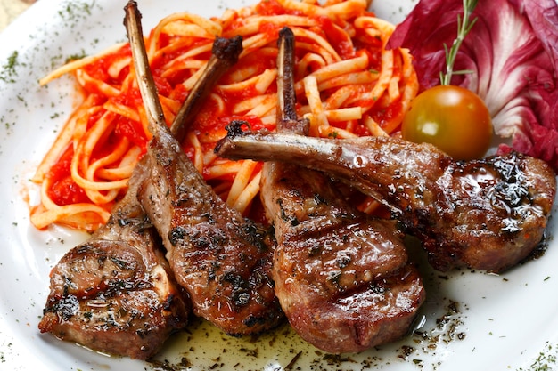 Gegrilde lamsrack met pasta en een glas rode wijn