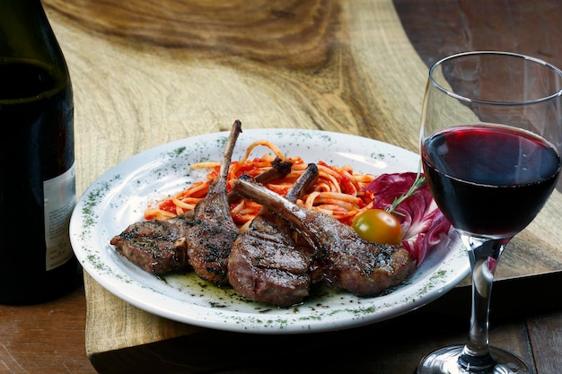 Gegrilde lamsrack met pasta en een glas rode wijn