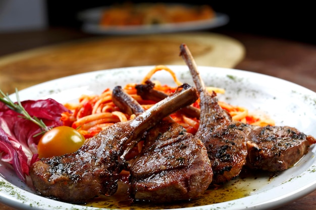 Gegrilde lamsrack met pasta en een glas rode wijn