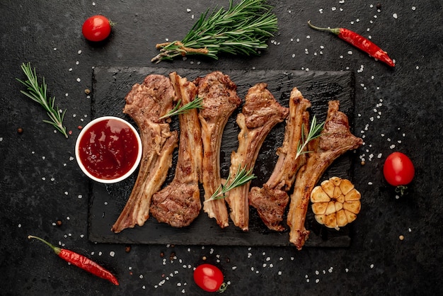 Gegrilde lamsribben met kruiden en knoflook op een stenen achtergrond