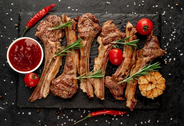 Gegrilde lamsribben met kruiden en knoflook op een stenen achtergrond