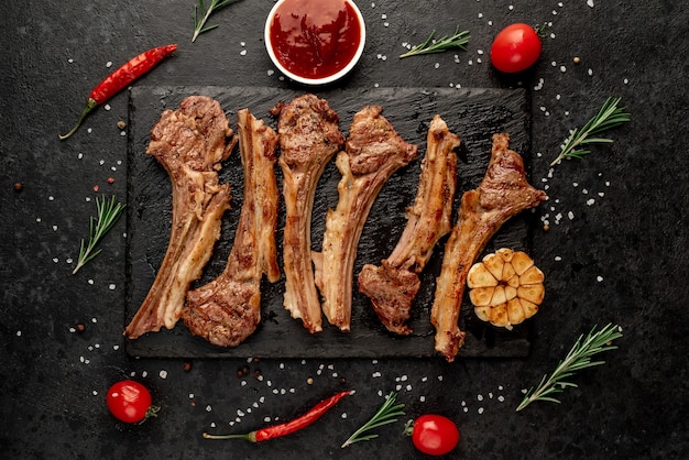 Gegrilde lamsribben met kruiden en knoflook op een stenen achtergrond