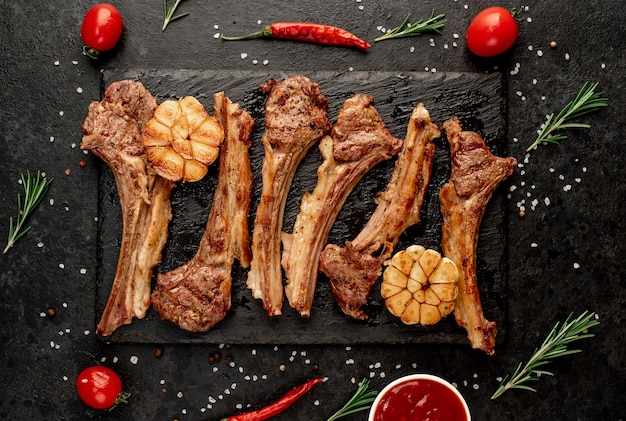 Gegrilde lamsribben met kruiden en knoflook op een stenen achtergrond