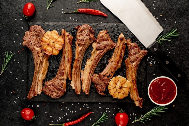 Gegrilde lamsribben met kruiden en knoflook op een stenen achtergrond