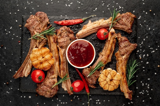 Gegrilde lamsribben met kruiden en knoflook op een stenen achtergrond