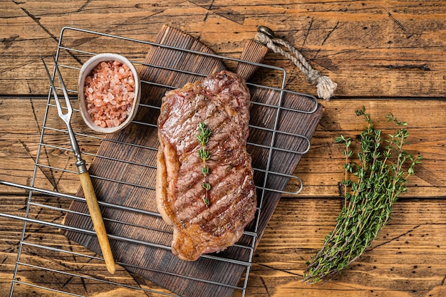 Gegrilde lendenen of New York beef steak gekookt op BBQ-houten achtergrond Top view