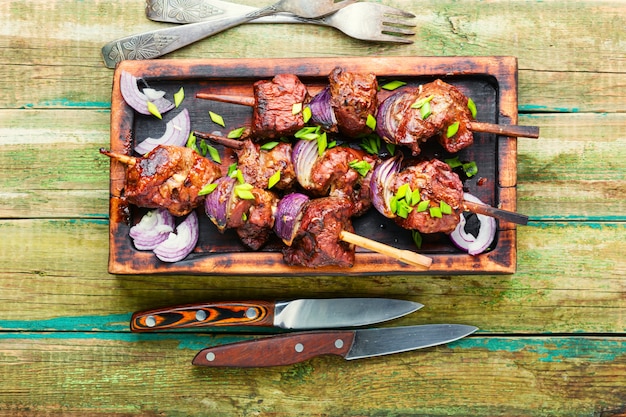 Gegrilde leverkebab met ui op houten spiesjes. Lekkere kebab op houten stokken