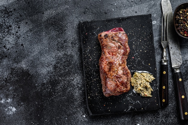 Gegrilde machete of biefstuk. Zwarte achtergrond. Bovenaanzicht.