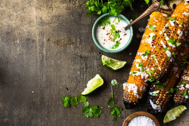 Gegrilde maiskolven eten met verse kruidenlimebier en salsa