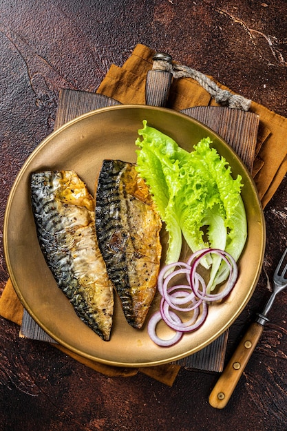 Gegrilde makreel scomber visfilets met garnituur in een bord donkere achtergrond bovenaanzicht