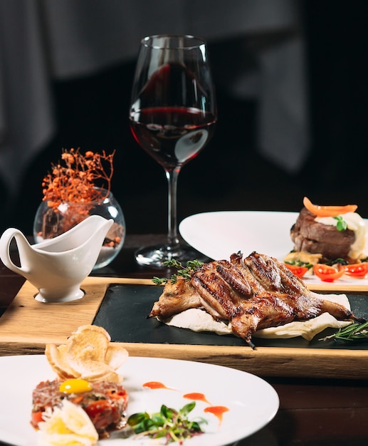 Gegrilde patrijs, zeebaars, Tartarus. Verschillende gerechten op tafel in het restaurant.