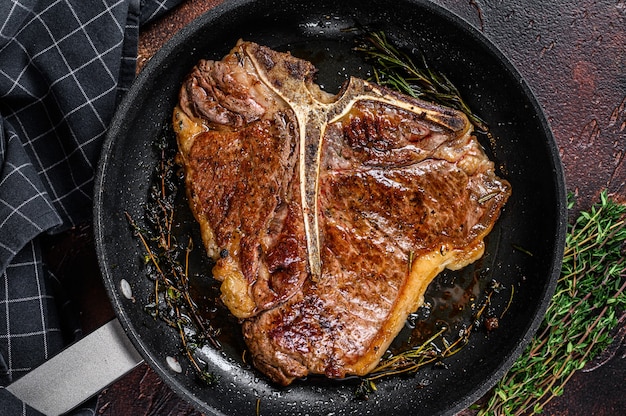 Gegrilde Porterhouse Rundvlees Steak Met Kruiden In Een Pan. Donkere achtergrond. Bovenaanzicht.