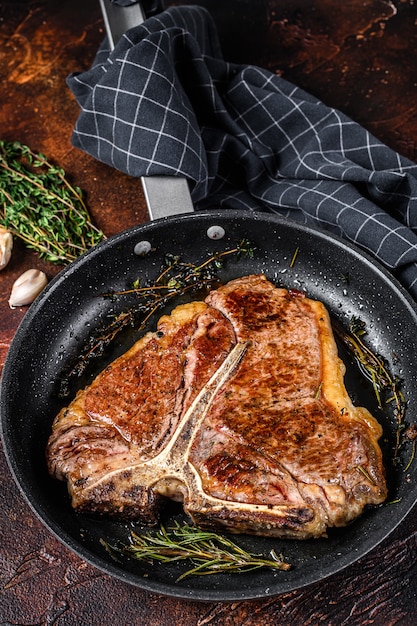 Gegrilde Porterhouse Rundvlees Steak Met Kruiden In Een Pan. Donkere achtergrond. Bovenaanzicht.