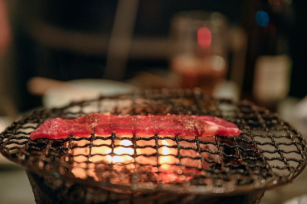 Gegrilde rauwe rundvleesplak op vlammende houtskoolgrill