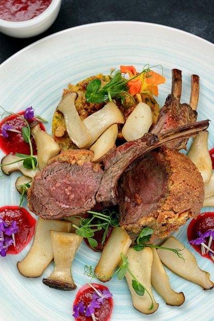 Foto gegrilde reeën met bosbessensaus en paddenstoelen met hazelnootparlin en parmezaanse kaas