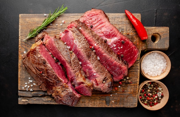 Gegrilde rib eye biefstuk met kruiden en specerijen op een stenen achtergrond