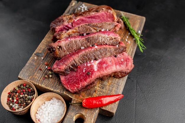 Gegrilde rib eye biefstuk met kruiden en specerijen op een stenen achtergrond