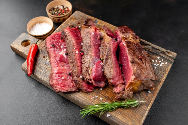 Gegrilde rib eye biefstuk met kruiden en specerijen op een stenen achtergrond