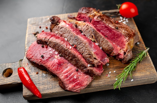 Gegrilde rib eye biefstuk met kruiden en specerijen op een stenen achtergrond