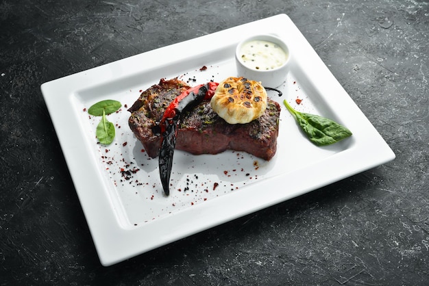 Gegrilde ribeye beef steak kruiden en specerijen op een bord Bovenaanzicht