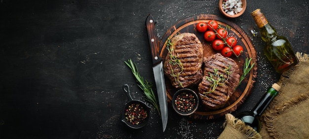 Gegrilde ribeye beef steak kruiden en specerijen op een donkere tafel Bovenaanzicht Vrije ruimte voor uw tekst